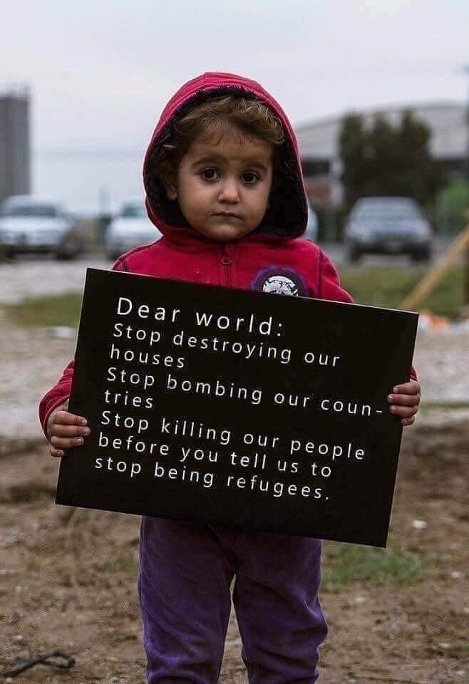 Sign held by small child says 'Dear world: Stop destroying our houses, stop bombing our countries, stop killing our people, before you tell us to stop being refugees.'